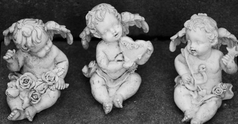 High-End Art - Three small figurines of angels sitting on a bench