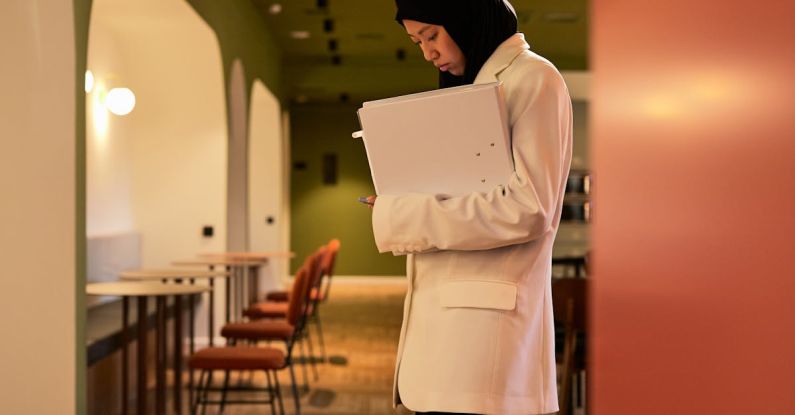 Fold-Down Desks - Woman in Hijab Standing Holding Papers