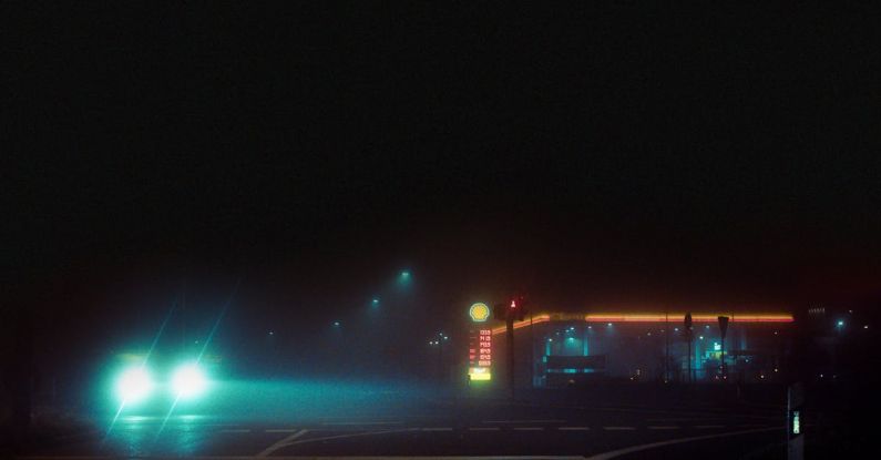 Neon Lights - A Car on a Dark Road Near Gas Station