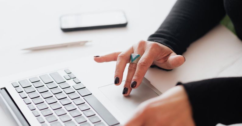 Smart Devices - Crop female using touchpad on laptop in office