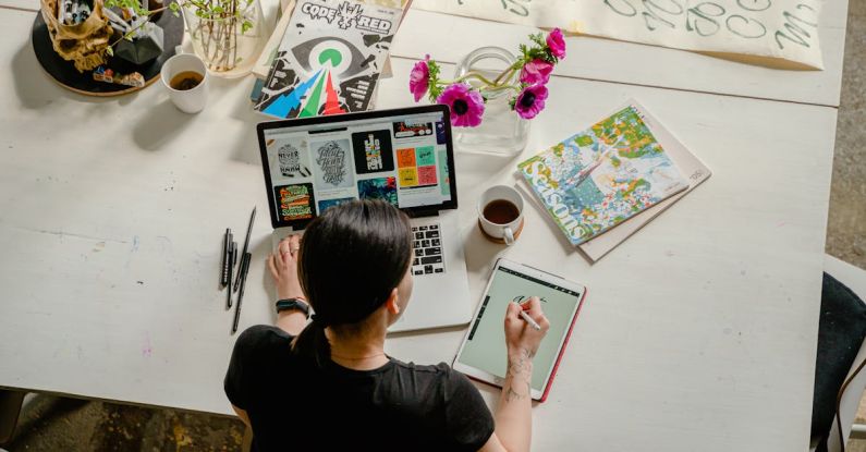 Craft Room - Photo of Woman Writing on Tablet Computer While Using Laptop