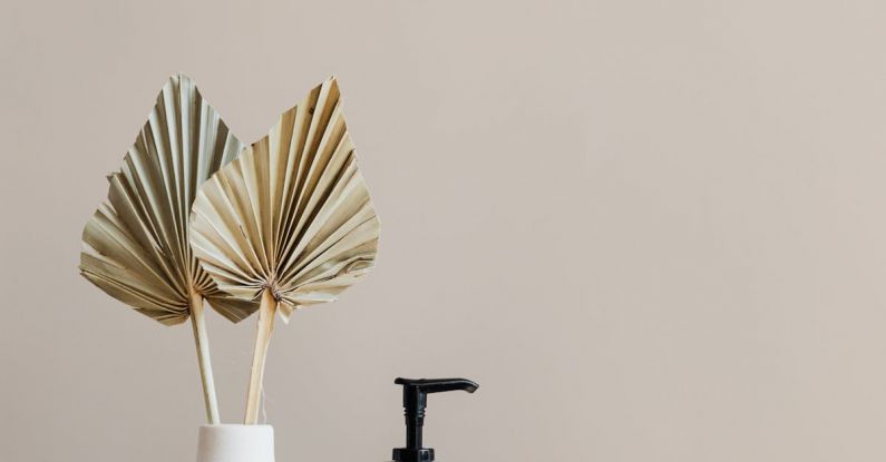 Bathroom Storage - Set of cosmetic supplies near decorative leaves in vase on marble shelf